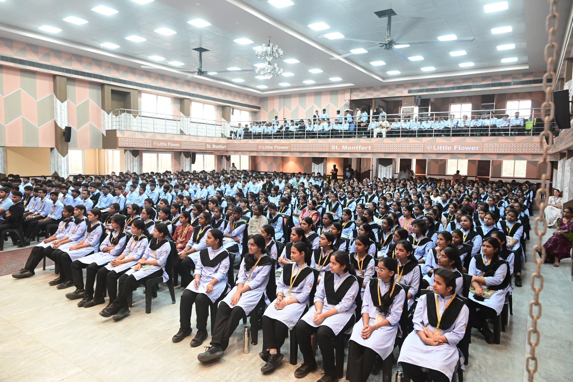 Students & Faculty seated in Tiered Auditorium & Balcony